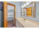 A cozy bathroom shows a vanity with a solid surface top and a doorway leading to the bedroom at 1705 N Ocean Blvd. N, North Myrtle Beach, SC 29582