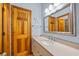 A cozy bathroom features a wooden door, light-colored vanity, and a starfish decoration at 1705 N Ocean Blvd. N, North Myrtle Beach, SC 29582