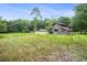 Old wooden barn nestled in a lush, overgrown field surrounded by trees at 1731 Lee Ln., Longs, SC 29568