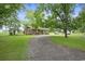 Charming brick house with a long gravel driveway surrounded by mature trees at 1731 Lee Ln., Longs, SC 29568