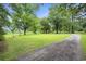 Expansive green lawn with mature trees and a long gravel driveway leading to the house at 1731 Lee Ln., Longs, SC 29568