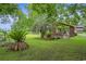 Lush green lawn with palm trees and a charming brick house at 1731 Lee Ln., Longs, SC 29568