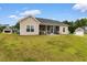 A tan home's backyard featuring a covered patio with outdoor seating and a spacious lawn at 177 Baylee Circle, Galivants Ferry, SC 29544