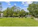 Green backyard with view of the lake, surrounded by lush trees and plants at 1776 Starbridge Dr., Surfside Beach, SC 29575