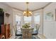 Bright dining area featuring a chandelier, a round glass table, and a bay window at 1776 Starbridge Dr., Surfside Beach, SC 29575