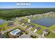 Aerial view showcasing homes, the community pool, playground, pond and natural green surroundings at 196 Cypress Tree Loop, Longs, SC 29568