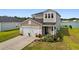 Charming two-story home featuring attached garage, landscaped yard, and lake view at 196 Cypress Tree Loop, Longs, SC 29568