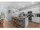 Bright kitchen with stainless steel appliances, a granite countertop island with barstool seating and white cabinetry at 196 Cypress Tree Loop, Longs, SC 29568