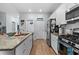 Modern kitchen equipped with stainless steel appliances, white cabinetry, and a spacious countertop island at 196 Cypress Tree Loop, Longs, SC 29568