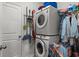 Efficient laundry room featuring stacked washer and dryer with hanging clothes and cleaning supplies at 196 Cypress Tree Loop, Longs, SC 29568