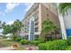 Multi-story condo building featuring a manicured lawn, tropical landscaping, and private balconies at 201 77Th Ave. N # 1133, Myrtle Beach, SC 29572