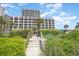 Exterior view of a high-rise hotel, with palm trees and a boardwalk on the beach at 201 77Th Ave. N # 1133, Myrtle Beach, SC 29572