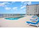 Inviting outdoor pool with ocean views and bright blue skies; features plenty of seating at 201 77Th Ave. N # 1133, Myrtle Beach, SC 29572