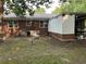 Backyard showcasing the rear exterior of the home with a brick facade, metal roof, and connected outbuilding at 205 S Oliver Blvd., Hemingway, SC 29554
