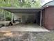 Spacious brick carport with metal roof, covering a storage area, connected to the house at 205 S Oliver Blvd., Hemingway, SC 29554