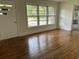 Sunlit living room with gleaming hardwood floors and large windows offering picturesque views at 205 S Oliver Blvd., Hemingway, SC 29554