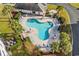 Aerial view of the uniquely shaped pool with ample seating surrounded by lush greenery and palm trees at 2241 Waterview Dr. # 514, North Myrtle Beach, SC 29582
