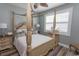 Elegant bedroom features a four-poster bed, wood floors, and natural light from the shuttered windows at 2428 Little River Neck Rd. # 101, North Myrtle Beach, SC 29582