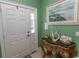 Inviting entryway with decorative table, white paneled front door, and attractive art at 2428 Little River Neck Rd. # 101, North Myrtle Beach, SC 29582