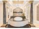 Luxurious bathroom features a large tub on a raised platform, columns, and an arched doorway to the shower at 2715 Ships Wheel Dr., North Myrtle Beach, SC 29582
