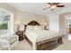 Elegant bedroom with a large bed, decorative lamps, and a cozy wicker chair by the window at 2715 Ships Wheel Dr., North Myrtle Beach, SC 29582
