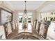 Elegant dining room features a long wooden table with decorative chairs, chandelier, and views of the waterfront at 2715 Ships Wheel Dr., North Myrtle Beach, SC 29582