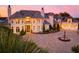 A luxurious home is beautifully landscaped and lit, highlighting a circular driveway with fountain at 2715 Ships Wheel Dr., North Myrtle Beach, SC 29582