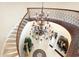 Grand foyer with curved staircase, ornate chandelier, iron railing, and tiled flooring at 2715 Ships Wheel Dr., North Myrtle Beach, SC 29582