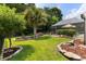 A landscaped backyard with a screened-in pool area and mature palms at 29 Saltwind Loop, Murrells Inlet, SC 29576