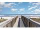Scenic beach boardwalk view with blue skies and ocean horizon, inviting a peaceful and relaxing vacation experience at 300 N Ocean Blvd. # 723, North Myrtle Beach, SC 29582