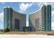 Stunning view of the modern condominium buildings with curved architecture on the beach, suggesting luxurious living at 300 N Ocean Blvd. # 723, North Myrtle Beach, SC 29582