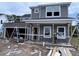 Two-story home featuring gray siding, white trim, a front porch, and an attached garage ready for final construction at 3038 Palma Way, Myrtle Beach, SC 29579