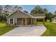 Well-maintained single-story house featuring gray siding, covered parking, and a spacious driveway at 306 S Magnolia Ave., Andrews, SC 29510