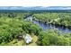 Stunning aerial view of a secluded riverfront home surrounded by lush green forest and blue skies at 3231 Center Rd., Georgetown, SC 29440