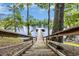 Wooden steps lead to a private dock offering a tranquil escape onto the serene lake waters at 3231 Center Rd., Georgetown, SC 29440