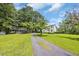 Long driveway leading to a charming white home with a green roof, and lush green lawn at 3231 Center Rd., Georgetown, SC 29440