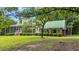 Exterior view of a home with a screened-in porch, a covered parking area, and lush landscaping at 3231 Center Rd., Georgetown, SC 29440