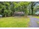 Quaint outbuilding with a rustic tin roof, nestled among mature trees and a well-maintained lawn at 3231 Center Rd., Georgetown, SC 29440