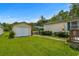 Large backyard with a well-maintained lawn, storage buildings and lush surrounding trees at 3839 Woodridge Circle, Little River, SC 29566