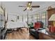 Bright main bedroom featuring wooden floors, ceiling fan, double closets, and a relaxing recliner by the window at 3839 Woodridge Circle, Little River, SC 29566