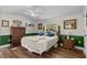 Sunlit bedroom with wooden floors, ceiling fan and a large bed with decorative pillows, offering a cozy retreat at 3839 Woodridge Circle, Little River, SC 29566