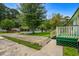 Landscaped front yard with a white picket fence and lush greenery on a sunny day at 3839 Woodridge Circle, Little River, SC 29566