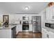 Bright kitchen showcasing stainless steel appliances, granite countertops, and ample white cabinets at 3839 Woodridge Circle, Little River, SC 29566