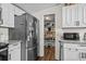 Bright kitchen featuring pantry access, stainless steel refrigerator, granite countertops, and white cabinets at 3839 Woodridge Circle, Little River, SC 29566