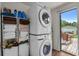 Efficient laundry area with stacked washer and dryer set and storage shelves, leading to outdoor access at 3839 Woodridge Circle, Little River, SC 29566