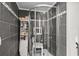 Modern glass enclosed shower featuring black tiled walls and chrome fixtures at 3839 Woodridge Circle, Little River, SC 29566