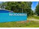 Bright blue Woodridge sign welcoming residents and visitors to this well-maintained community at 3839 Woodridge Circle, Little River, SC 29566