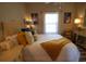Comfortable bedroom featuring a wicker headboard, soft lighting, and a cozy yellow throw blanket at 390 Lands End Blvd. # 4-201, Myrtle Beach, SC 29572