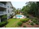 Aerial view of community pool surrounded by lush landscaping and palm trees at 390 Lands End Blvd. # 4-201, Myrtle Beach, SC 29572