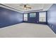 Bedroom with blue accent wall, two windows, and neutral carpeting at 4115 Alvina Way, Myrtle Beach, SC 29579